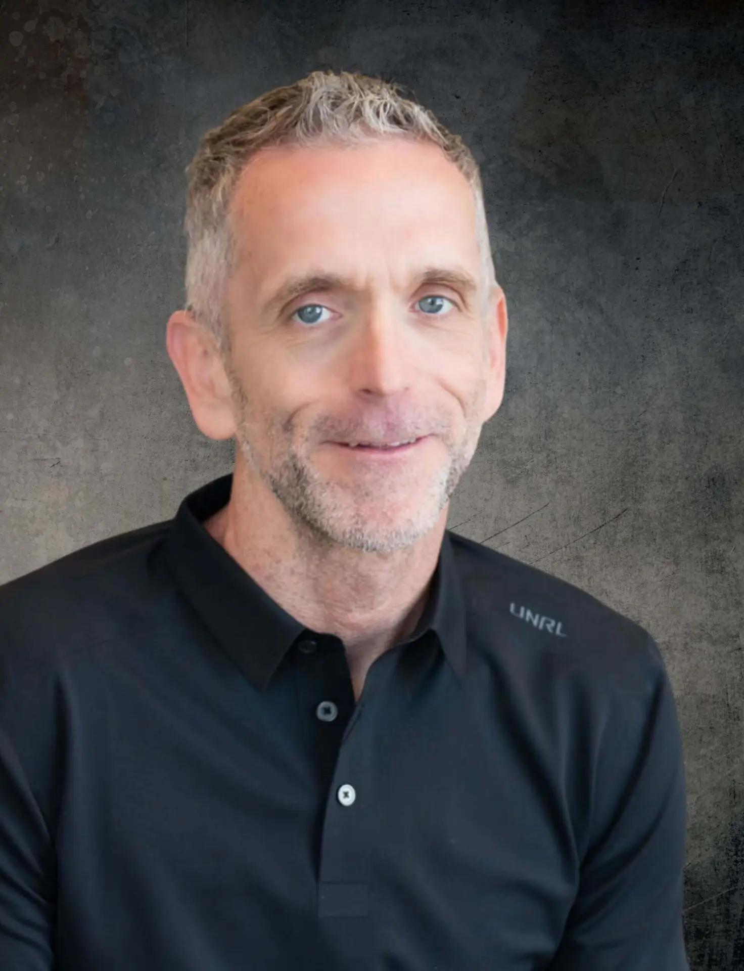 Rich Zieske, PA-C, wearing a black polo shirt, smiling against a light gray background.